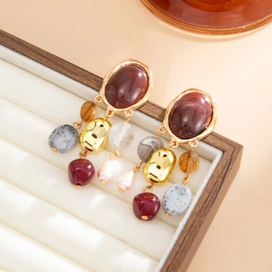 Detailed shot of vintage French earrings with colorful beads and stones in a display box