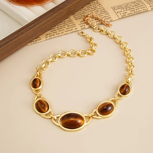 Detailed close-up of vintage gold-plated chain necklace with tiger eye resin stones
