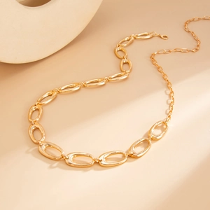 Macro view of gold minimalist waist chain with polished irregular hollow oval links