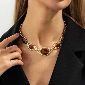 Retro gold Y-shaped necklace with five oval tiger eye gemstones worn on model