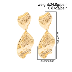 Détail de boucles d'oreilles ginkgo dorées montrant la longueur de 6 cm et le poids