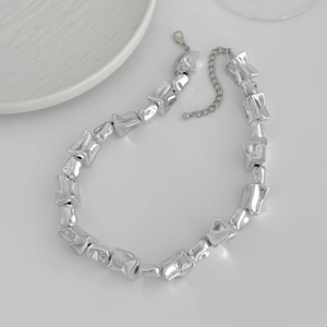 Detail van de karabijnsluiting en verlengketting op de zilveren onregelmatige ketting