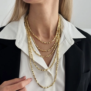 Layered gold cube bead necklace featuring five tiers of geometric metallic strands