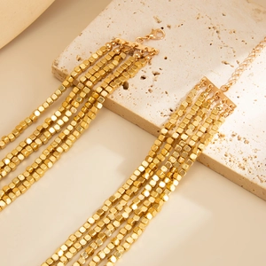 Close-up of layered gold CCB square beaded necklace with lobster clasp on stone