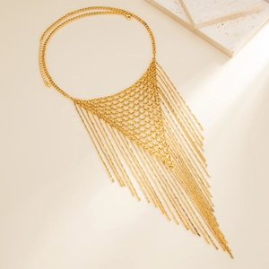 Detailed view of golden mesh chain necklace with long tassels on marble stone background