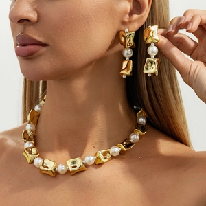 Set van choker ketting en oorbellen met onregelmatige gouden metalen stukken en parels