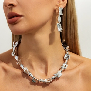 Sjieke zilveren set van geplooide ketting en oorbellen in een minimalistische stijl