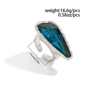 Detail of silver hammer-textured ring with faceted blue gemstone and size measurements