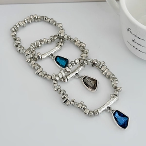 Detailed view of elastic beaded bracelets with three colors of faceted crystal pendants