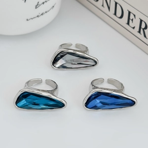 Detail view of three adjustable silver rings with blue and grey triangle cut gemstones