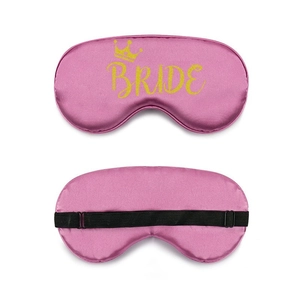 Detail showing the adjustable elastic strap and golden Bride text on pink satin eye mask