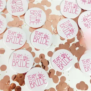 Detail of white and pink Team Bride tinplate badges with diamond graphics for parties