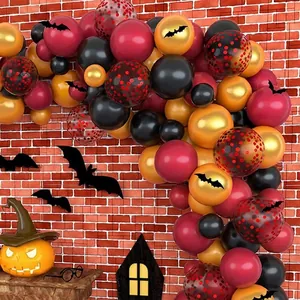 Halloween arch kit with red, black, and gold balloons featuring bats on brick background