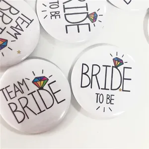 Vista macro di distintivi in latta bianchi con testo Bride To Be e motivi a diamante