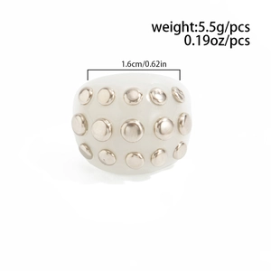 Detail view of a white chunky resin ring featuring silver metal studs and size dimensions