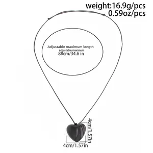 Detail view of large matte black heart pendant with dimensions and adjustable cord specs