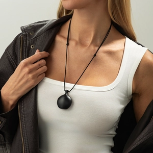 Detail of minimalist black matte teardrop pendant on an adjustable long cord necklace