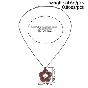 Detail view of coffee-colored flower pendant with crystal and adjustable cord dimensions
