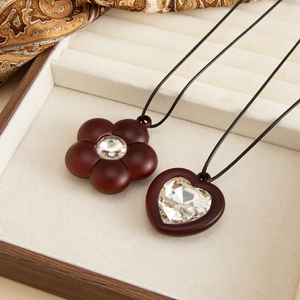 Detail of heart and flower wooden pendants with crystals in a luxury jewelry box