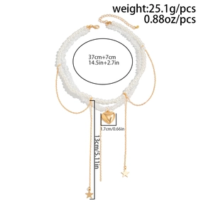 Detailed view of double-layer necklace with pearls, gold heart pendant and tassel star charms