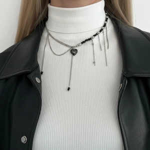 Chic layered necklace with silver tassels and black heart pendant on a model