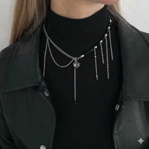 Multi-layer silver fringe necklace with heart pendant and black beads on black leather jacket