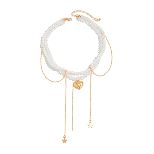 Layered faux pearl and gold heart pendant necklace with star charms on white background