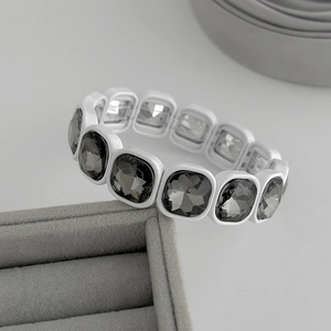 Gros plan détaillé du bracelet en émail blanc avec cristaux gris foncé de coupe carrée