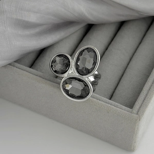 Vue détaillée d'une bague argentée avec pierres acryliques grises sur velours
