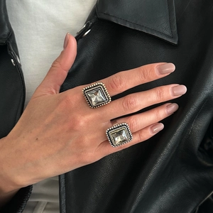 Bagues rétro en argent avec pierres carrées en acrylique portées avec une veste en cuir