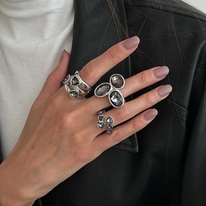 Ensemble de bagues vintage en argent avec pierres grises portées sur la main sur un cuir