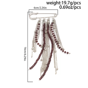 Detailed view of tassel brooch with silver chains and red beads including size measurements