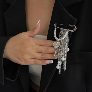 Silver fringe tassel pin brooch with pearls and heart pendant on a black blazer suit jacket