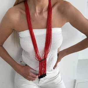 Bohemian multi-layer red seed bead necklace with black crystal tassel worn by a model