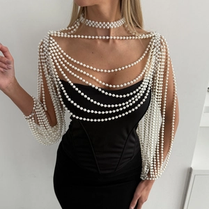 Elegant multi-layer pearl body chain jewelry worn over a black strapless evening dress