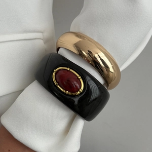 Détail de bracelet en résine avec pierre d'ambre et bracelet jonc doré poli superposés