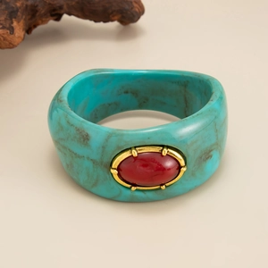 Vue détaillée d'un bracelet en résine bohème bleu sarcelle avec pierre rouge centrale