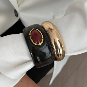 Ensemble de bracelets rétro en résine et or portés par un mannequin en veste