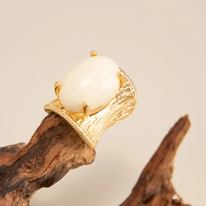 Detailed view of the vintage gold ring featuring a large white cabochon gem and textured band