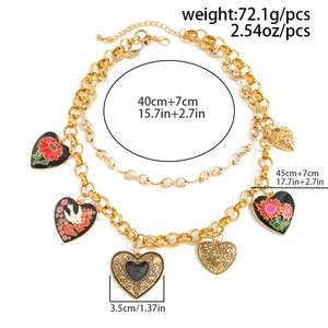 Detailed view of layered gold chunky chain necklace with floral enamel heart charms