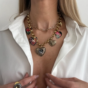 Close-up of vintage gold multi-layered heart pendants with enamel and floral patterns