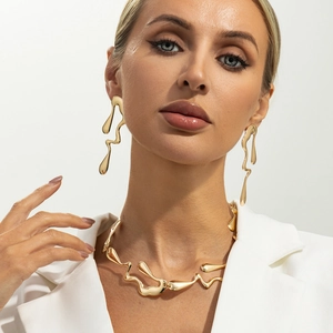 Détail du parure de bijoux en métal doré liquide avec collier et boucles d'oreilles