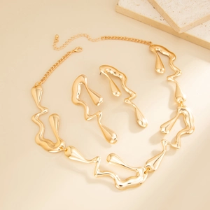 Vue détaillée d'une parure dorée avec collier et boucles d'oreilles au design liquide