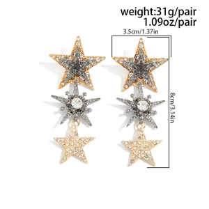 Dettaglio di orecchini a stella a tre livelli con placcatura oro argento e strass lucidi