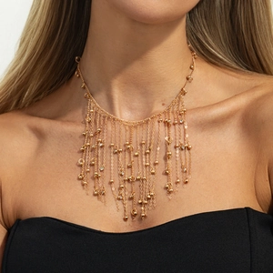 Detail of luxury gold tassel necklace with crystal beads on model neck close-up