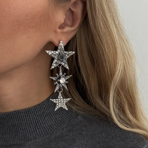 Orecchini a stella in argento con cristalli scintillanti indossati da una modella donna