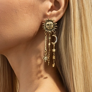 Gros plan de boucles d'oreilles soleil et lune vintage avec perles sur un mannequin