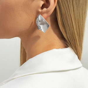 Gros plan sur les boucles d'oreilles géométriques en argent avec zircons sur un mannequin