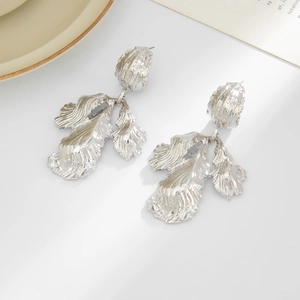 Détail macro de boucles d'oreilles feuilles argentées avec surface métallique texturée