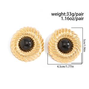 Détail de boucles d'oreilles vintage dorées avec spirale et pierre en résine noire